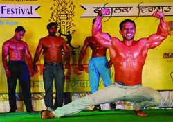 A participant flexes his muscles during a body-building fashion show organised during the Fazilka heritage festival. 