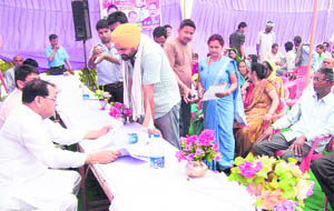 Revenue Minister Yashpal Arya (extreme left) listens to the problems of the people at a janta darbar programme at Bazpur on Monday. 