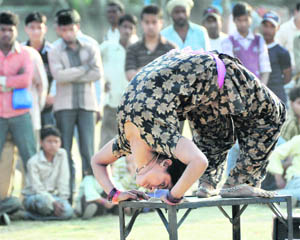 A girl shows her talent to earn money during a road show in Dehradun on Sunday. 
