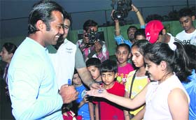 Tennis player Leander Paes interacts with budding players at a tennis academy in Jalandhar on Monday