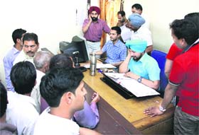 Applicants wait for the server to be upgraded with new collector rates in Jalandhar on Monday