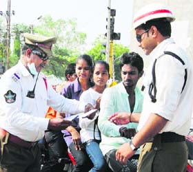 Policemen check admission tickets of students coming to appear in exams in a curfew-bound area at Maddanapet in Hyderabad on Monday