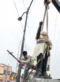 An employee of the Municipal Corporation removes the statue of Dr BR Ambedkar from the Clock Tower for relocation nearby in Dehradun on Tuesday