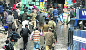 Protesting government employees being chased away by the police in Srinagar on Tuesday. 