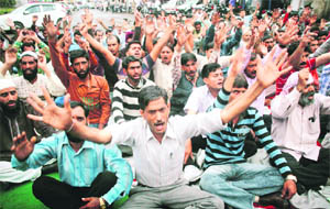 Members of the J&K Daily Wagers Joint Action Forum, Jammu Province, stage a protest in support of their demands in Jammu on Tuesday. 