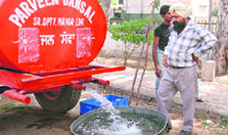A resident gets water from a tanker during the summer season in Ludhiana.