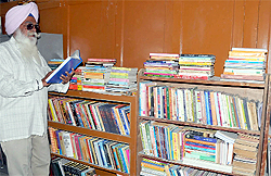 Niranjan Singh Premi browses through a book at the newly-opened Sahib-e-Kamaal Guru Gobind Singh Public Library in Bathinda on Wednesday