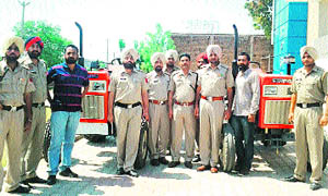 Police personnel pose with the recovered tractors. 