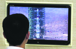 A scientist looks at a monitor showing the Unha-3 rocket on a launch pad on the outskirts of Pyongyang.