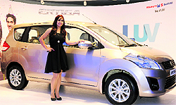 A model poses with the new Maruti Suzuki Ertiga in New Delhi on Thursday. The auto major unveiled variants of its first multiutility vehicle, powered with 1373cc VVT petrol and 1248cc DDiS superturbo VGT diesel engines and priced from Rs 589,000 to Rs 845,000