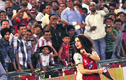 Actress Preity Zinta, co-owner of KIngs XI Punjab, throws a T-shirt at cricket fans at the PCA Stadium in Mohali on Thursday