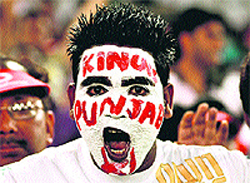 A youth paints his face to show support for his team Kings XI Punjab