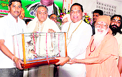 Uttarakhand Chief Minister Vijay Bahuguna being offered a memento by Braham Swaroop Brahamchari at Jai Ram Ashram in Haridwar on Thursday