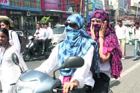 Beating the Heat: Girls cover their faces to protect themselves from the scorching sun in Rohtak