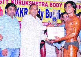 Ram Swaroop Chopra, president of the Indian National Lok Dal, Thanesar, (third from left), gives away the Mr Kurukshetra-2012 Trophy to Vikas Saini at Kurukshetra