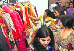 Visitors take a look at clothes on display at the Lifestyle Pakistan exhibition. 