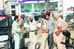 Police officials inspect the spot from where Sant Singh was abducted in Ludhiana 
