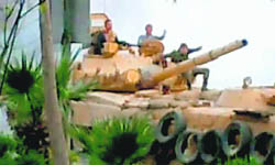 Syrian soldiers patrolling on a Syrian army tank after Friday prayers in the Damascus suburb of Kafr Betna