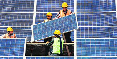 Haryana, too, can save energy on the Gujarat pattern (pic). Workers give finishing touches to solar panels at the Gujarat solar park at a village in Patan district.