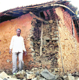 A villager stands next to his house that was damaged during a 4.9-magnitude quake at Gohsatwadi village in Satara, Maharashtra, on Saturday. 