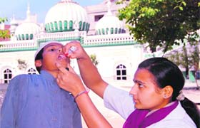 A health worker administers polio drops to a child in front of a mosque in Amritsar on Sunday