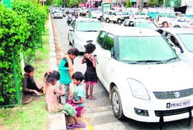 Children beg at a traffic signal near Lawrence road chowk in Amritsar on Sunday