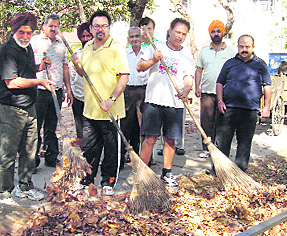 Residents of Sector 21, Chandigarh, sweep a road in their area on Sunday.