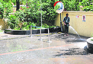 A worker of the Hometel hotel in Industrial Area, Phase I, cleans the parking lot of the hotel on Sunday.