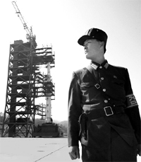 A North Korean soldier standing in front of the long-range rocket, which plunged into the sea just over a minute after take-off.