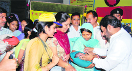 Urban Local Bodies Minister Gopal Kanda administers polio drops to a child at Sirsa on Sunday.