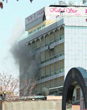 Smoke billows out of a hotel after a rocket strike.