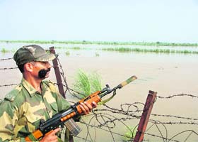 A jawan keeps an eye across the fence in Ferozepur sector of Punjab