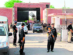 Security officials at the damaged main entrance of a prison following an attack by armed militants in Bannu, Pakistan, on Sunday