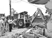 A JCB being used to remove an encroachment near Dera Bassi on Monday.