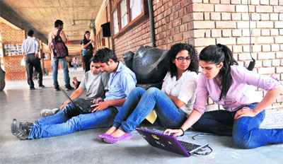Students spend time surfing the Internet in a college corridor in Chandigarh.