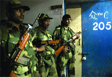 BSF jawans guard a room where EVMs are kept at NP (Bengali) Girls Senior Secondry School at Gole Market in New Delhi on Monday. 