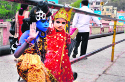 Playing GodTwo children in the attire of Lord Shiva and Goddess Parvati on a bridge at the Ganga ghat in Haridwar