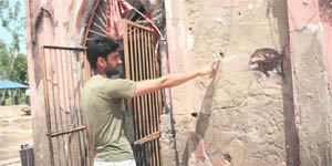A villager shows bullet marks on the wall of the temple. 