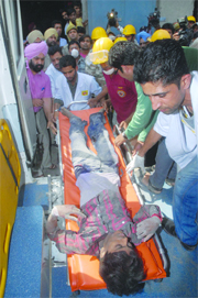 The NDRF team rescues an injured labourer in Jalandhar on Monday.
