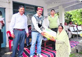 A woman being given a gas stove with connection by MLA Sanjay Choudary under the Mata Shabri programme at Kangra on Tuesday