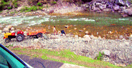 A tractor trailer being used to carry boulders from the Tirthan in the Balichowki area.