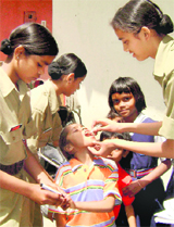 NCC cadets administer polio drops to a boy during a campaign in Chandigarh.