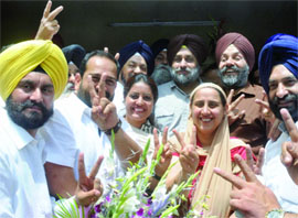 Deputy Chief Minister of Punjab Sukhbir Singh Badal poses with candidates of his party who won the MCD elections, at his residence in New Delhi on Wednesday