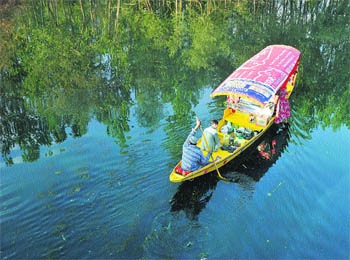 A boatman navigates on the Dal Lake in Srinagar. Tourism workers are hoping that the summer will bring tourist rush to the scenic region. 