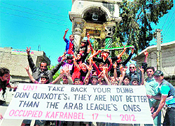 Protesters flash the sign for victory during an anti-government demonstration in Kfranabel, Idlib