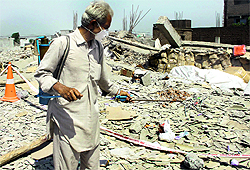 A worker sprays tamiphos at the factory collapse site to check the spread of any disease in Jalandhar on Thursday