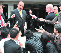 Former Olympus Corp president & CEO Michael Woodford (top, C) speaks to reporters upon his arrival at an extraordinary shareholders meeting in Tokyo on Friday.