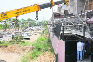 A fallen electricity pole on a huse at Sector 79 in Mohali on Friday. 