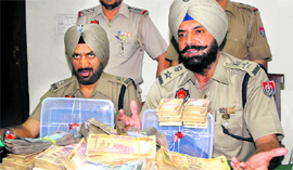 The SSP (Rural) shows the cash a weapon recovered from the accused.