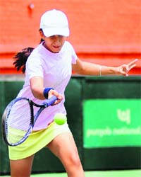 A tennis player plays a shot during her match at the CLTA Complex in Chandigarh on Saturday